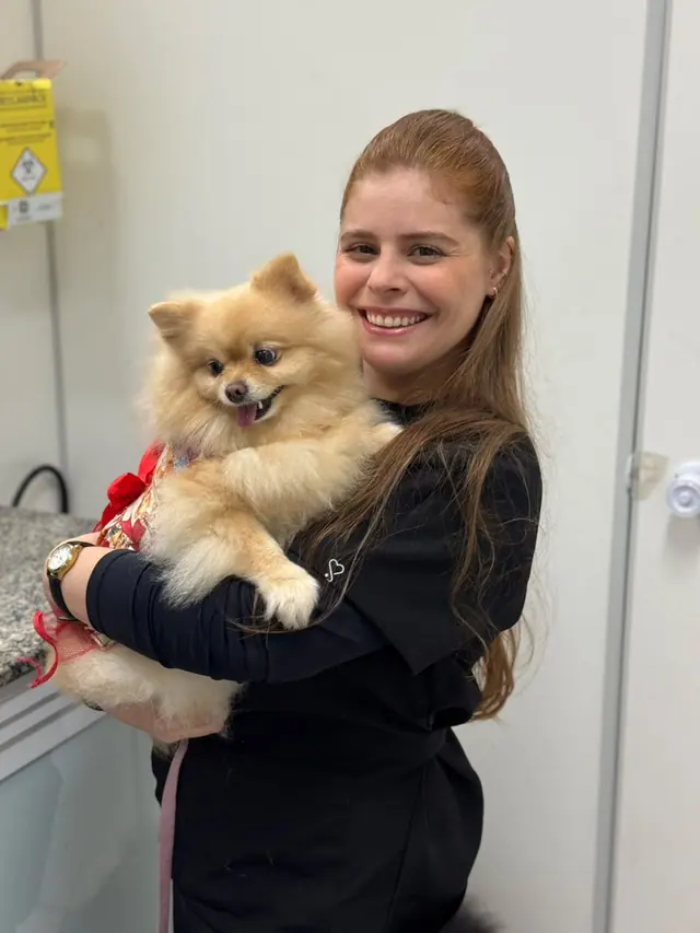 Veterinária da LerVet sorrindo com um cãozinho no colo