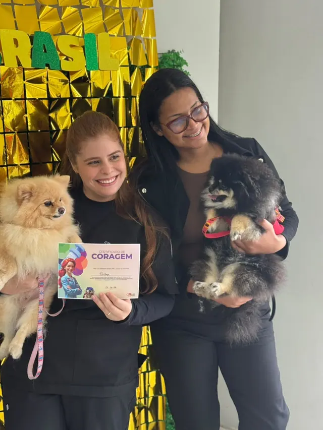 Tutores recebendo o Certificado de Coragem com seus pets na LerVet